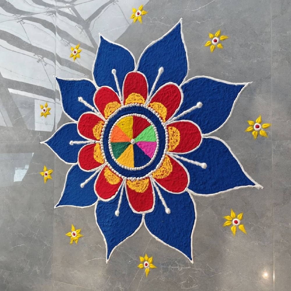 ਰੰਗੋਲੀ ਦਾ ਇਹ ਡਿਜ਼ਾਈਨ ਬਣਾਉਣਾ ਵੀ ਬਹੁਤ ਆਸਾਨ ਹੈ। ਇਸ ਡਿਜ਼ਾਈਨ ਨੂੰ ਤੁਸੀਂ ਘਰ ਜਾਂ ਮੰਦਰ 'ਚ ਕਿਤੇ ਵੀ ਬਣਾ ਸਕਦੇ ਹੋ। ਨੀਲੇ, ਪੀਲੇ ਅਤੇ ਮੈਰੂਨ ਨਾਲ ਬਣਿਆ ਇਹ ਡਿਜ਼ਾਈਨ ਬਹੁਤ ਹੀ ਖੂਬਸੂਰਤ ਲੱਗਦਾ ਹੈ। ਨਾਲ ਹੀ ਨੇੜੇ-ਤੇੜੇ ਛੋਟੇ ਤਾਰੇ ਬਣਾਏ ਗਏ ਹਨ।