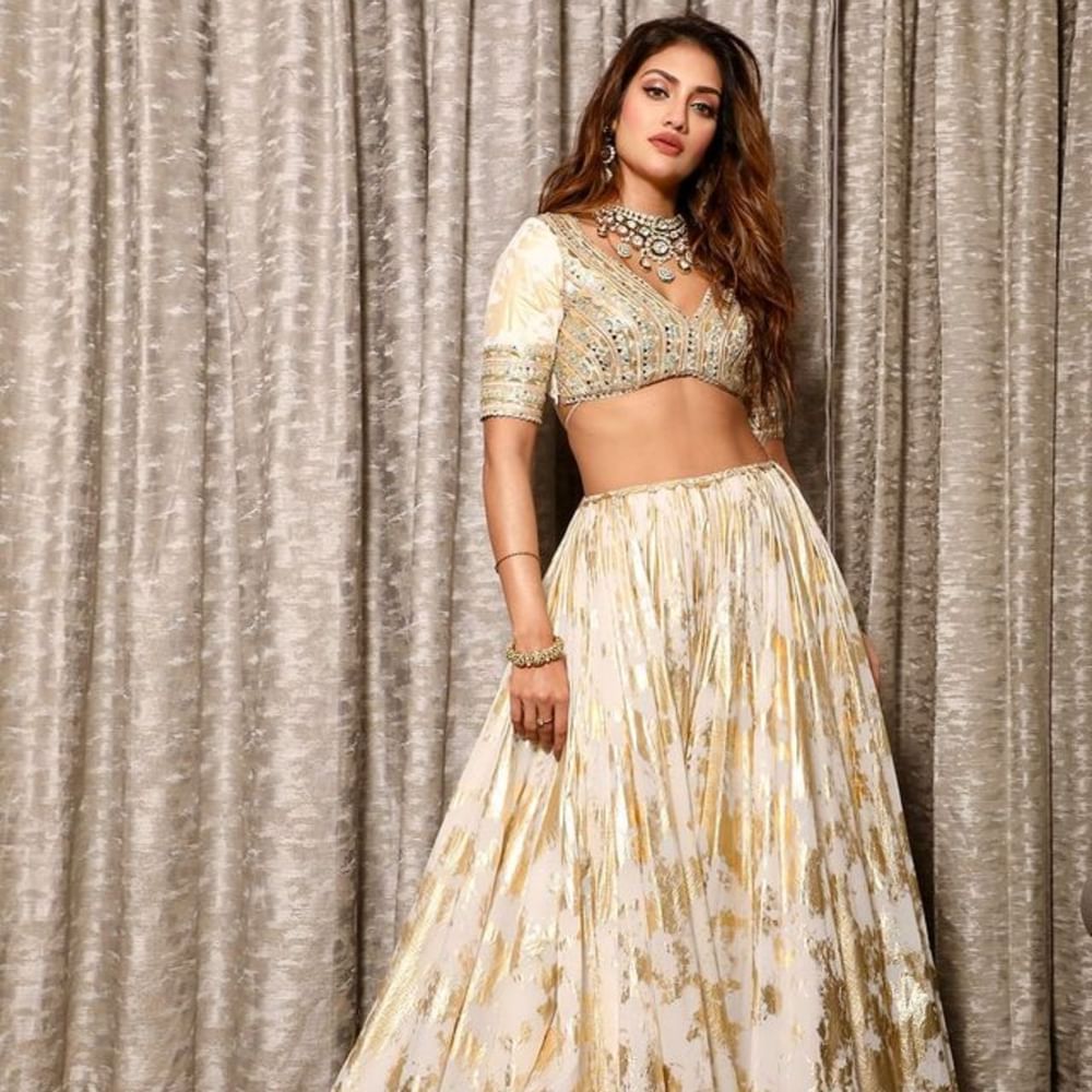 ਤੁਹਾਨੂੰ ਆਪਣੇ ਕਲੈਕਸ਼ਨ ਵਿੱਚ ਇਹ ਕਲਾਸੀ ਆਫ ਵ੍ਹਾਈਟ ਗੋਲਡਨ ਫਲੋਰਲ ਪ੍ਰਿੰਟ ਲਹਿੰਗਾ ਜ਼ਰੂਰ ਸ਼ਾਮਲ ਕਰਨਾ ਚਾਹੀਦਾ ਹੈ। ਨੁਸਰਤ ਨੇ ਵੀ ਨੈਕ ਵਾਲਾ ਕੁਆਰਟਰ ਸਲੀਵ ਬਲਾਊਜ਼ ਸਟਾਈਲ ਕੀਤਾ ਹੈ। ਇਸ ਦੇ ਨਾਲ ਹੀ ਅਦਾਕਾਰਾ ਨੇ ਸਟੇਟਮੈਂਟ ਜਵੈਲਰੀ ਕੈਰੀ ਕੀਤੀ ਹੈ, ਜੋ ਲੁੱਕ ਨੂੰ ਕੰਪਲੀਟ ਕਰ ਰਹੀ ਹੈ।