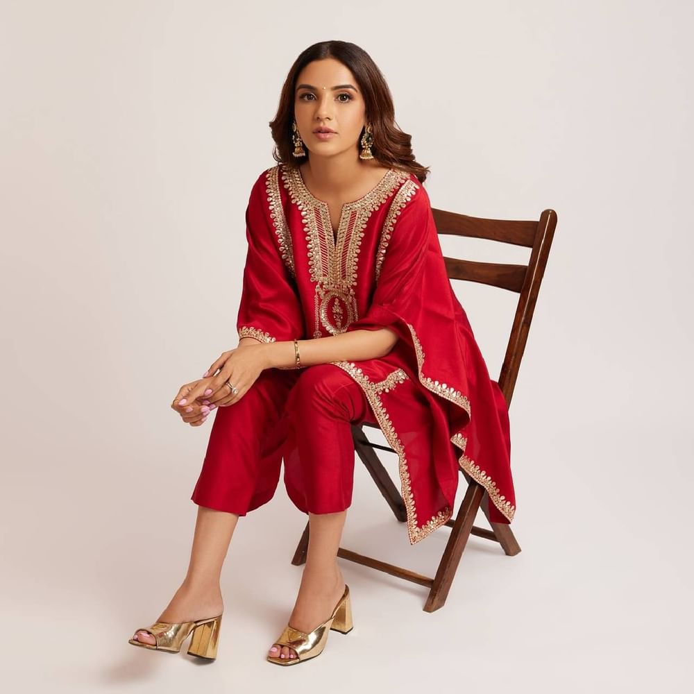 ਜੈਸਮੀਨ ਭਸੀਨ ਇਸ ਲਾਲ ਰੰਗ ਦੇ ਕਢਾਈ ਵਾਲੇ ਕਫ਼ਤਾਨ ਸਟਾਈਲ ਸੂਟ ਵਿੱਚ ਬਹੁਤ ਸੁੰਦਰ ਲੱਗ ਰਹੀ ਹੈ। ਅਦਾਕਾਰਾ ਨੇ ਆਪਣੇ ਲੁੱਕ ਨੂੰ ਹਾਈ ਹੀਲਜ਼ ,ਵਾਲੀਆਂ ਨਾਲ ਕੰਪਲੀਟ ਕੀਤਾ ਹੈ।( Credit : jasminbhasin2806 )