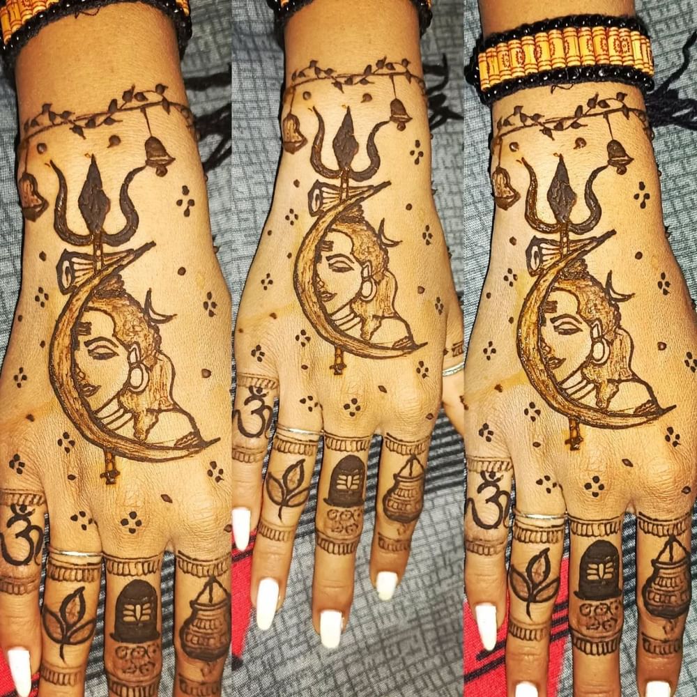 ਇਹ ਮਹਿੰਦੀ ਡਿਜ਼ਾਈਨ ਵੀ ਸੁੰਦਰ ਅਤੇ Unique ਲੱਗ ਰਿਹਾ ਹੈ। ਇਸ ਵਿੱਚ ਡਮਰੂ, ਤ੍ਰਿਸ਼ੂਲ ਅਤੇ ਭਗਵਾਨ ਸ਼ਿਵ ਦੀ ਤਸਵੀਰ ਹੈ। ਨਾਲ ਹੀ, ਉਂਗਲਾਂ 'ਤੇ ਓਮ, ਬੇਲਪੱਤਰ ਦੇ ਪੱਤੇ, ਸ਼ਿਵਲਿੰਗ ਅਤੇ ਮਟਕੀ ਦੀਆਂ ਤਸਵੀਰਾਂ ਖਿੱਚੀਆਂ ਜਾਂਦੀਆਂ ਹਨ। ਇਸ ਕਿਸਮ ਦਾ ਡਿਜ਼ਾਈਨ ਬਹੁਤ ਆਕਰਸ਼ਕ ਦਿਖਾਈ ਦੇਵੇਗਾ। ( Credit : sona_nails_mehendi )