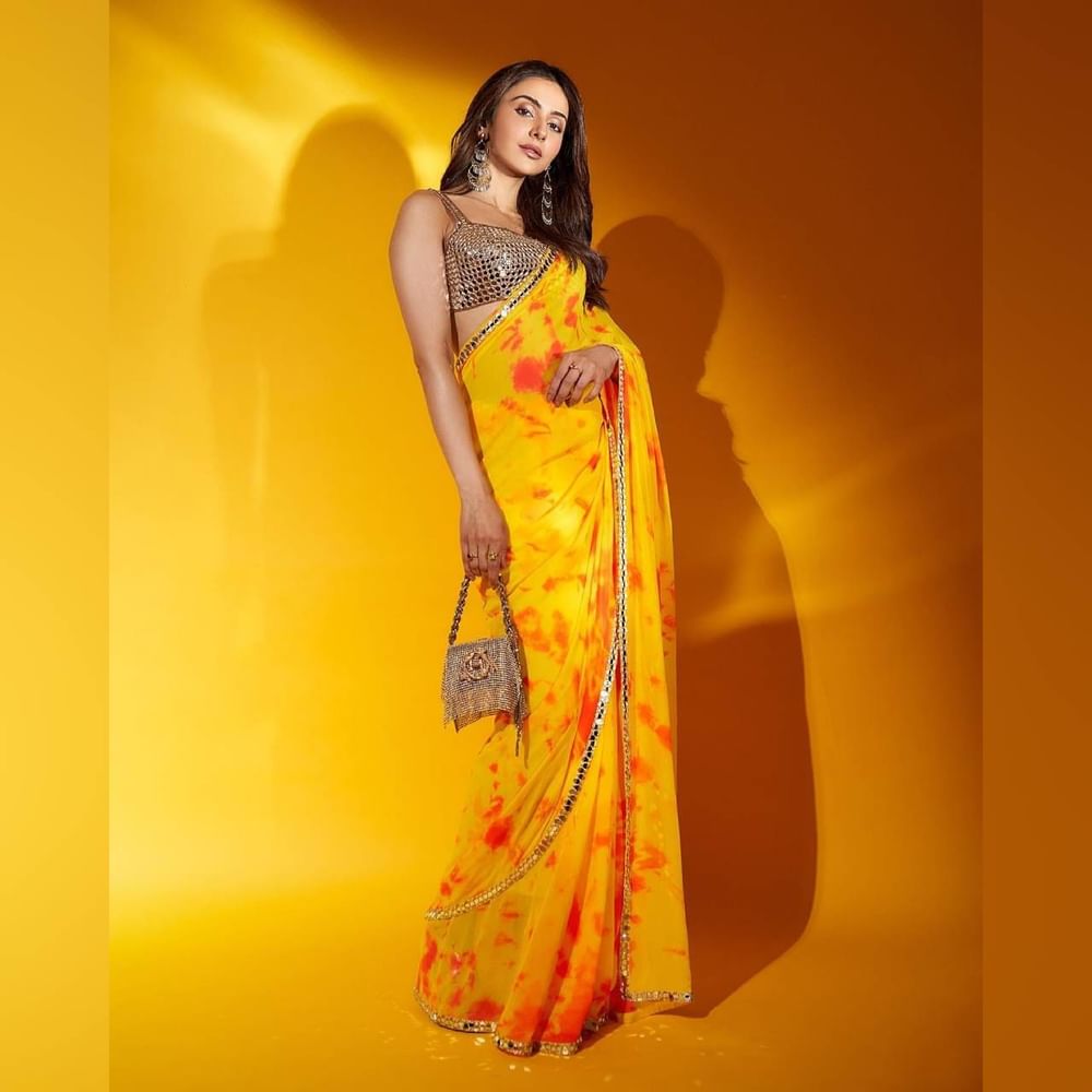 ਰਕੁਲ ਪ੍ਰੀਤ ਨੇ ਜਾਰਜੇਟ ਵਿੱਚ ਪੀਲੇ ਰੰਗ ਦੀ ਟਾਈ ਅਤੇ ਰੰਗ ਦੀ ਹੱਥ ਨਾਲ ਬਣੀ ਸਾੜੀ ਪਹਿਨੀ ਹੈ। ਸਾੜੀ ਦੇ ਕਿਨਾਰਿਆਂ ਦੇ ਨਾਲ-ਨਾਲ ਬਲਾਊਜ਼ 'ਤੇ ਵੀ ਸ਼ੀਸ਼ੇ ਅਤੇ ਕਢਾਈ ਦਾ ਕੰਮ ਹੈ। ਇਸ ਕਿਸਮ ਦੀ ਹਲਕੀ ਸਾੜੀ ਹਰ ਖਾਸ ਮੌਕੇ ਲਈ ਵਧੀਆ ਆਪਸ਼ਨ ਹੈ।( Credit : rakulpreet )