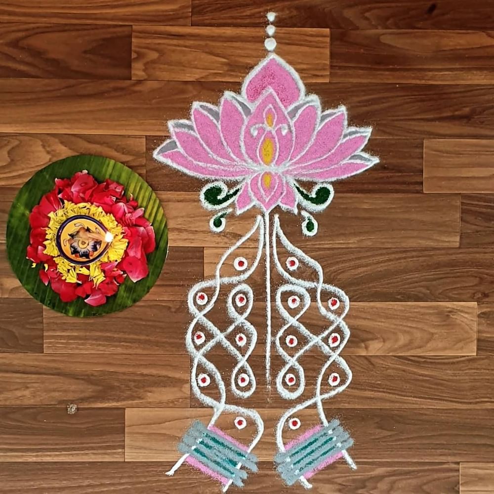 ਨਰਾਤਿਆਂ ਲਈ ਇਸ ਰੰਗੋਲੀ ਡਿਜ਼ਾਈਨ ਤੋਂ ਆਈਡੀਆ ਲੈ ਸਕਦੇ ਹੋ। ਡਿਜ਼ਾਈਨ ਵਿੱਚ ਚਿੱਟੇ ਅਤੇ ਹਲਕੇ ਗੁਲਾਬੀ ਰੰਗ ਦਾ ਇਸਤੇਮਾਲ ਕਰਕੇ ਕਮਲ ਦਾ ਫੁੱਲ ਬਣਾਇਆ ਗਿਆ ਹੈ ਅਤੇ ਔਰਤ ਦੇ ਹੱਥ ਨਾਲ ਨਮਸਕਾਰ ਕਰਨ ਦਾ ਡਿਜ਼ਾਈਨ ਦਿਖਾਇਆ ਗਿਆ ਹੈ। ਨਾਲ ਹੀ, ਗੁਲਾਬ ਅਤੇ ਗੇਂਦੇ ਦੀਆਂ ਪੱਤੀਆਂ ਇੱਕ ਪਾਸੇ ਪੱਤੇ ਉੱਤੇ ਰੱਖੀਆਂ ਹਨ। ( Credit : kolam_page_samiksha )