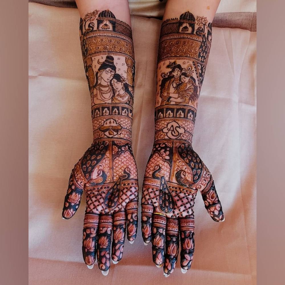 ਇਹ ਮਹਿੰਦੀ ਡਿਜ਼ਾਈਨ ਬਹੁਤ ਵਧੀਆ ਲੱਗ ਰਿਹਾ ਹੈ। ਜੇਕਰ ਤੁਸੀਂ ਵਿਲੱਖਣ ਅਤੇ ਸਭ ਤੋਂ ਸੁੰਦਰ ਮਹਿੰਦੀ ਲਗਾਉਣਾ ਚਾਹੁੰਦੇ ਹੋ, ਤਾਂ ਤੁਸੀਂ ਇਸ ਡਿਜ਼ਾਈਨ ਤੋਂ ਆਈਡੀਆ ਲੈ ਸਕਦੇ ਹੋ। ਇਸ ਵਿੱਚ ਮੋਰ ਅਤੇ ਜਾਲੀ ਦਾ ਡਿਜ਼ਾਈਨ ਬਣਾਇਆ ਗਿਆ ਹੈ। ਇਸ ਤੋਂ ਇਲਾਵਾ, ਇੱਕ ਹੱਥ 'ਤੇ ਭਗਵਾਨ ਸ਼ਿਵ ਅਤੇ ਪਾਰਵਤੀ ਦੀ ਤਸਵੀਰ ਅਤੇ ਦੂਜੇ ਹੱਥ 'ਤੇ ਗੁੱਟ 'ਤੇ ਰਾਧਾ-ਕ੍ਰਿਸ਼ਨ ਦੀ ਤਸਵੀਰ ਬਣਾਈ ਗਈ ਹੈ। ਇਹ 3D ਮਹਿੰਦੀ ਡਿਜ਼ਾਈਨ ਵੀ ਬਹੁਤ ਵਧੀਆ ਲੱਗਦਾ ਹੈ। ( Credit : urmi_mehendi_artist )
