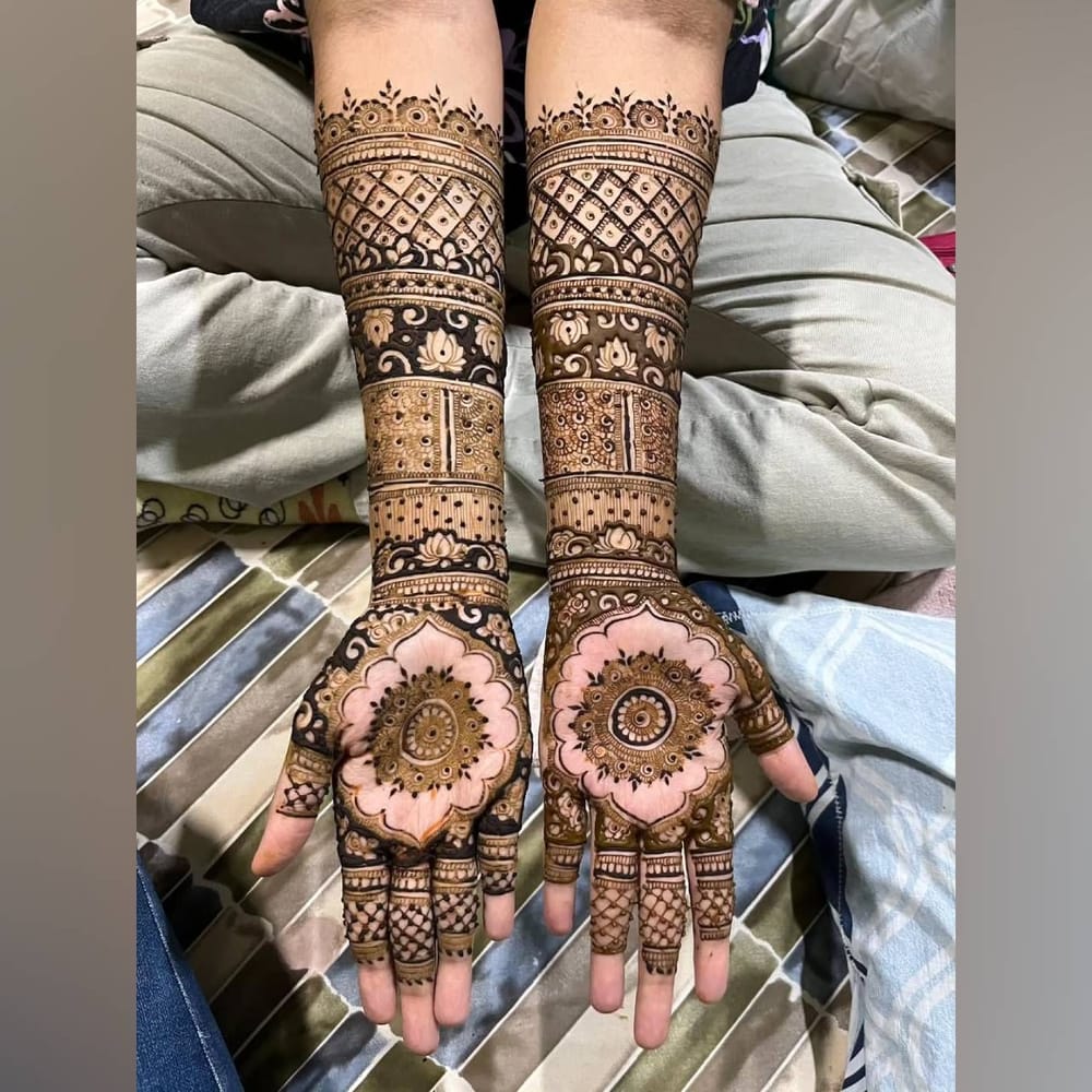 ਇਹ ਮਹਿੰਦੀ ਡਿਜ਼ਾਈਨ ਬਹੁਤ ਸੋਹਣਾ ਲੱਗ ਰਿਹਾ ਹੈ। ਜੇਕਰ ਤੁਸੀਂ ਪੂਰੇ ਹੱਥ 'ਤੇ ਸਿੰਪਲ ਮਹਿੰਦੀ ਲਗਾਉਣਾ ਚਾਹੁੰਦੇ ਹੋ, ਤਾਂ ਇਹ ਤੁਹਾਡੇ ਲਈ ਸਭ ਤੋਂ ਵਧੀਆ ਹੋਵੇਗਾ। ਵਿਚਕਾਰ ਇੱਕ ਸਧਾਰਨ ਡਿਜ਼ਾਈਨ ਦੇ ਨਾਲ ਇੱਕ Circle ਬਣਾਇਆ ਹੈ ਅਤੇ ਇਸਦੇ ਆਲੇ-ਦੁਆਲੇ ਡਿਜ਼ਾਈਨ ਜੋੜੇ ਗਏ ਹਨ। ਇਸ ਤੋਂ ਇਲਾਵਾ ਗੁੱਟ 'ਤੇ ਜਾਲ ਅਤੇ ਕਮਲ ਦੇ ਫੁੱਲ ਦਾ 3D ਡਿਜ਼ਾਈਨ ਵੀ ਬਣਾਇਆ ਗਿਆ ਹੈ। ( Credit : smituuz_art )