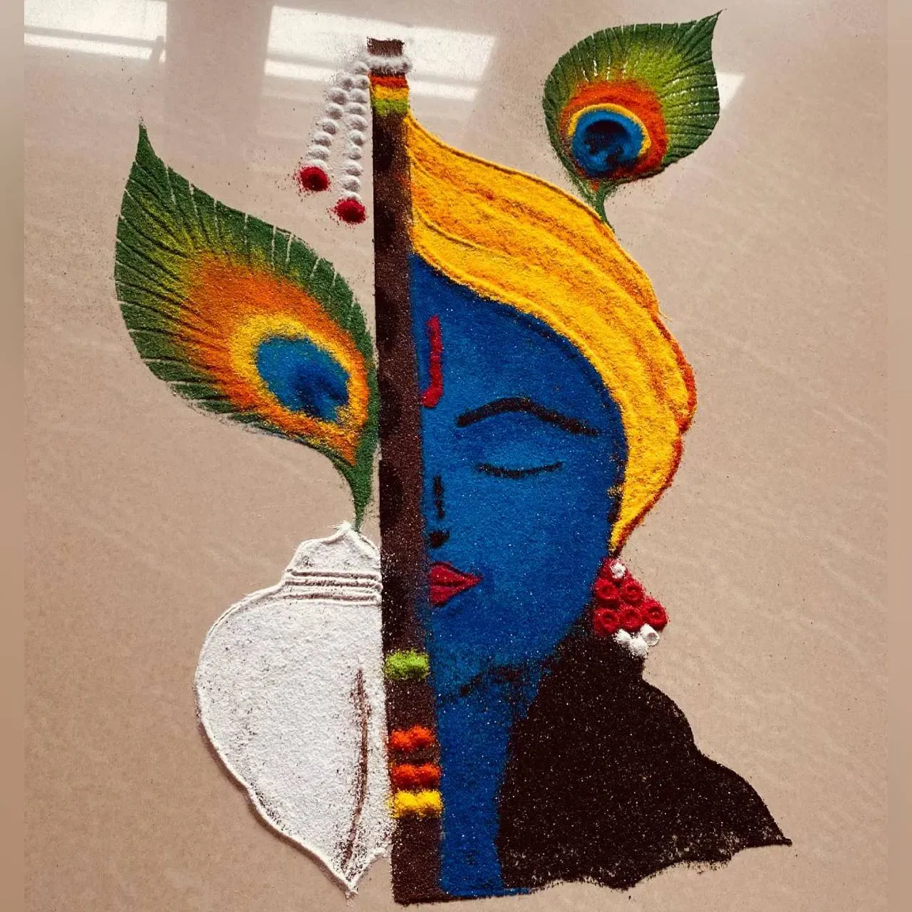 ਤੁਸੀਂ ਇਸ ਰੰਗੋਲੀ ਡਿਜ਼ਾਈਨ ਦੀ ਕਾਪੀ ਕਰ ਸਕਦੇ ਹੋ। ਇਸ ਵਿੱਚ ਇੱਕ ਪਾਸੇ ਭਗਵਾਨ ਕ੍ਰਿਸ਼ਨ ਦਾ ਚਿੱਤਰ, ਬੰਸਰੀ, ਸ਼ੰਖ ਅਤੇ ਮੋਰ ਦੇ ਖੰਭ ਦੀ ਤਸਵੀਰ ਹੈ, ਜੋ ਕਿ ਬਹੁਤ ਸੁੰਦਰ ਲੱਗਦੀ ਹੈ। ਤੁਸੀਂ ਆਪਣੇ ਪੂਜਾ ਕਮਰੇ ਲਈ ਇਸ ਰੰਗੋਲੀ ਡਿਜ਼ਾਈਨ ਤੋਂ ਆਇਡੀਆ ਵੀ ਲੈ ਸਕਦੇ ਹੋ। (Credit : kalavithi_00)