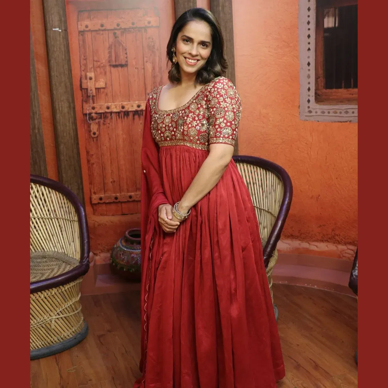 ਸਾਇਨਾ ਨੇਹਵਾਲ ਇਸ ਰਿਚ ਐਂਬ੍ਰਾਇਡਰੀ ਵਾਲੇ ਰੈੱਡ ਐਥਨਿਕ ਗਾਊਨ ਵਿੱਚ ਬਹੁਤ ਹੀ ਗੌਰਜਿਅਸ ਲੱਗ ਰਹੀ ਹੈ। ਅਨਾਰਕਲੀ ਦਾ ਫਲੋਈ ਫਲੇਅਰਡ ਸਕਰਟ ਉਨ੍ਹਾਂ ਦੇ ਲੁੱਕ ਵਿੱਚ ਗ੍ਰੇਸ ਨੂੰ ਐਡ ਕਰਦਾ ਹੈ। ਨੈਚੁਰਲ ਮੇਕਅੱਪ ਉਨ੍ਹਾਂ ਦੀ ਬਿਊਟੀ ਫੈਸ਼ਨ ਦੇ ਇੱਕ ਕਮਾਲ ਦੀ ਚੁਆਇਸ ਬਣਾਉਂਦਾ ਹੈ।