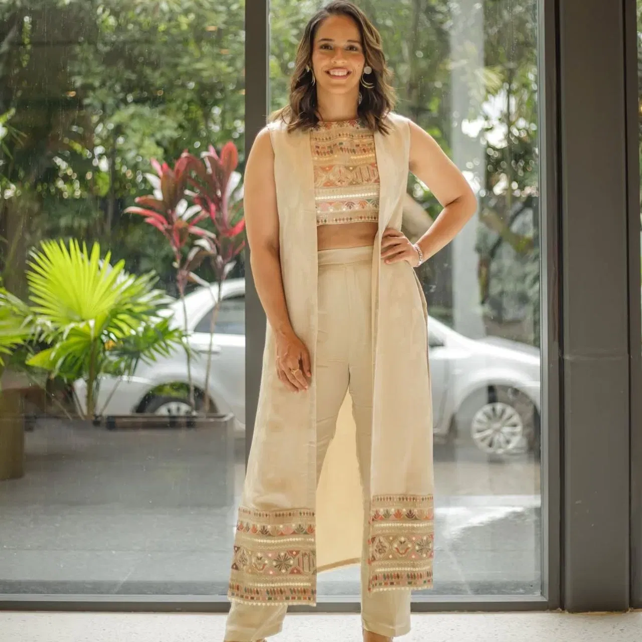 ਸਾਇਨਾ ਨੇਹਵਾਲ ਦਾ ਇੰਡੋ-ਵੈਸਟਰਨ ਲੁੱਕ ਆਧੁਨਿਕ ਸਟਾਈਲ ਨੂੰ ਟ੍ਰੇਡੀਸ਼ਨਲ ਫੈਸ਼ਨ ਨਾਲ ਸੰਤੁਲਿਤ ਕਰਦਾ ਹੈ। ਉਸਦਾ ਲੁੱਕ ਬ੍ਰੋਕੇਡ ਡਿਟੇਲਸ ਵਾਲੇ ਕ੍ਰੌਪ ਟਾਪ ਅਤੇ ਮੈਚਿੰਗ ਟਰਾਊਜ਼ਰ ਦੇ ਨਾਲ ਲੌਂਗ ਜੈਕੇਟ ਦੇ ਨਾਲ ਇਹ ਲੁੱਕ ਐਲੀਗੈਂਟ ਹੈ। ਈਅਰਿੰਗਸ ਅਤੇ ਸਾਫਟ ਹੇਅਰ ਵੇਵਸ ਨਾਲ ਆਪਣੇ ਸਟਾਈਲ ਨੂੰ ਕੰਪਲੀਟ ਕੀਤਾ ਹੈ।