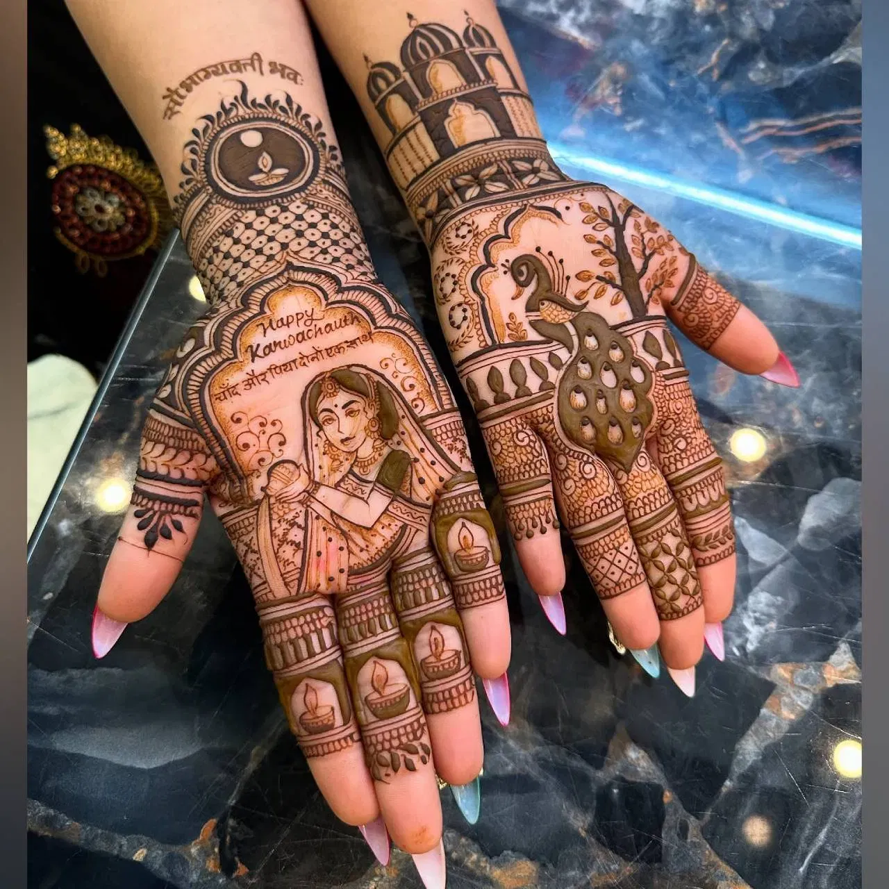 ਮਹਿੰਦੀ ਦਾ ਇਹ ਡਿਜ਼ਾਈਨ ਬਹੁਤ ਯੂਨੀਕ ਲੱਗ ਰਿਹਾ ਹੈ। ਇਹ ਇੱਕ ਔਰਤ ਨੂੰ ਅਰਘਿਆ ਦਿੰਦੇ ਹੋਏ ਦਿਖਾਇਆ ਗਿਆ ਹੈ, ਜਿਸ ਵਿੱਚ ਸੋਲਾਹ ਸ਼ਿੰਗਾਰ (ਸੋਲ੍ਹਾਂ ਸ਼ਿੰਗਾਰ) ਨੂੰ ਬਹੁਤ ਬਾਰੀਕੀ ਨਾਲ ਦਰਸਾਇਆ ਗਿਆ ਹੈ। ਇਸ ਦੇ ਆਲੇ-ਦੁਆਲੇ ਸਿੰਪਲ ਡਿਜ਼ਾਈਨ ਪਾ ਕੇ ਉੱਪਰ "ਹੈਪੀ ਕਰਵਾ ਚੌਥ" ਲਿਖਿਆ ਹੋਇਆ ਹੈ। ਉਂਗਲਾਂ 'ਤੇ ਦੀਵੇ ਦੇ ਡਿਜ਼ਾਈਨ ਬਣਾਏ ਗਏ ਹਨ। ਦੂਜੇ ਪਾਸੇ ਇੱਕ ਰੁੱਖ, ਮੋਰ ਅਤੇ ਇੱਕ ਮਹਿਲ ਦਾ 3D ਡਿਜ਼ਾਈਨ ਬਣਾਇਆ ਗਿਆ ਹੈ। ( ਕ੍ਰੈਡਿਟ: 3d_henna_touch)