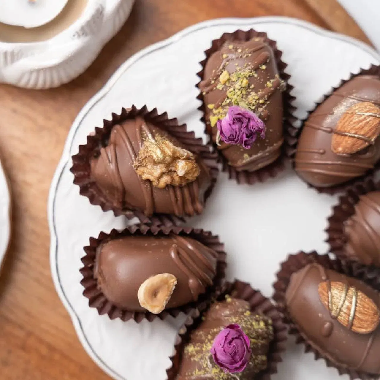 ਛਿੱਲੇ ਹੋਏ ਬਦਾਮ ਨੂੰ ਥੋੜਾ ਜਿਹਾ ਮੋਟਾ ਪੇਸਟ ਬਣਾ ਲਓ, ਫਿਰ ਇਸ ਵਿੱਚ ਵਾਈਟ ਚਾਕਲੇਟ ਪਾਓ ਅਤੇ ਸਾਫਟ ਪੇਸਟ ਬਣਾਓ। ਹੁਣ ਬਗੈਰ ਬੀਜ ਵਾਲੀ ਖਜੂਰ ਨੂੰ ਲਵੋਂ ਅਤੇ ਉਸਨੂੰ ਬਦਾਮ ਦੇ ਪੇਸਟ ਨਾਲ ਭਰੋ। ਇਸਦੇ ਵਿਚ ਭੁੰਨੇ ਹੋਏ ਅਖਰੋਟ ਵੀ ਪਾ ਸਕਦੇ ਹੋ। ਇਨ੍ਹਾਂ ਨੂੰ ਮੈਲਟੇਡ ਚਾਕਲੇਟ ਨਾਲ ਪੂਰੀ ਤਰ੍ਹਾਂ ਕਵਰ ਕਰੋ  ਅਤੇ ਗੁਲਾਬ ਦੀਆਂ ਪੱਤੀਆਂ ਨਾਲ ਸਜਾਓ। ਹੁਣ ਫਰਿੱਜ ਵਿੱਚ ਰੱਖੋ।