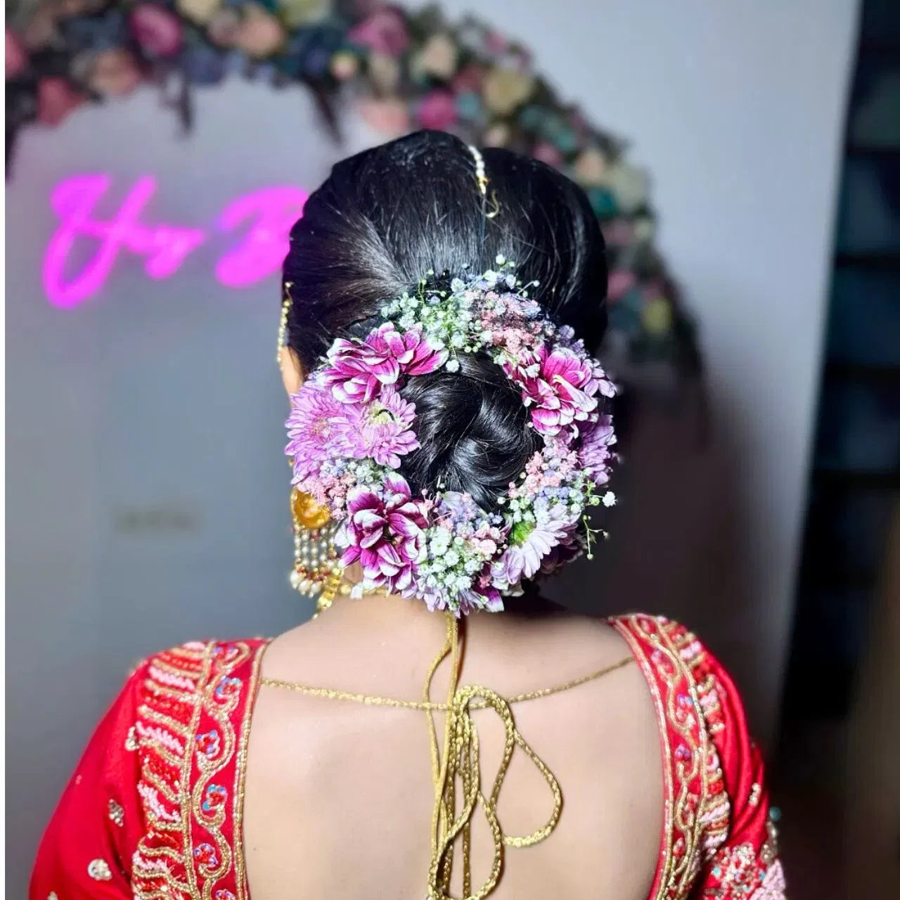 ਬ੍ਰਾਈਡਲ ਐਟਾਇਰ ਤੇ ਬੰਨ ਹਮੇਸ਼ਾ ਪਸੰਦ ਕੀਤਾ ਜਾਂਦਾ ਰਿਹਾ ਹੈ। ਇਹ ਕਦੇ ਵੀ ਆਉਟ ਆਫ ਟ੍ਰੈਂਡ ਨਹੀਂ ਹੁੰਦਾ ਹੈ। ਜੇਕਰ ਤੁਸੀਂ ਵੀ ਆਪਣੇ ਵਿਆਹ ਲਈ ਜੂੜਾ ਬਣਾਉਣਆ ਚਾਹੁੰਦੇ ਹੋ, ਤਾਂ ਤੁਸੀਂ ਇਸ ਹੇਅਰ ਸਟਾਈਲ ਦੀ ਕਾਪੀ ਕਰ ਸਕਦੇ ਹੋ। ਇਸ ਵਿੱਚ ਵਾਲਾਂ ਨੂੰ ਕ੍ਰੀਂਪ ਕਰਕੇ ਫ੍ਰੈਂਚ ਚੋਟੀ ਬਣਾਈ ਗਈ ਹੈ, ਅਤੇ ਜੂੜਾ ਬਣਾ ਕੇ ਫੁੱਲਾਂ ਨਾਲ ਸਜਾਇਆ ਗਿਆ ਹੈ। (Credit: priya_chauhan_hairartist/Instagram)