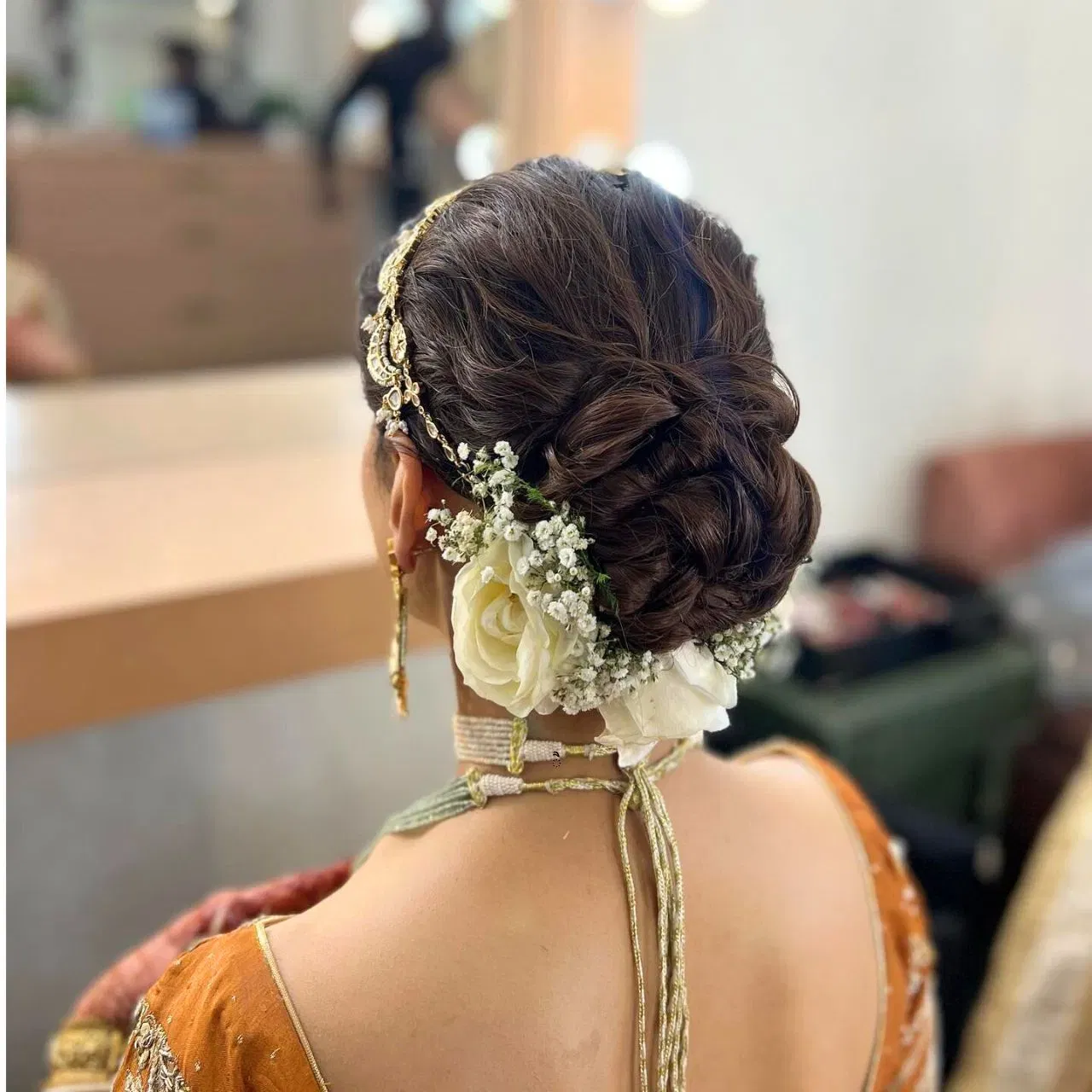 ਮੈਸੀ ਜੂੜਾ ਵੀ ਬ੍ਰਾਈਡਲ ਲੁੱਕ ਲਈ ਇੱਕ ਵਧੀਆ ਆਪਸ਼ਨ ਹੈ। ਇਸਨੂੰ ਬਣਾਉਣ ਲਈ, ਵਾਲਾਂ ਨੂੰ ਪਹਿਲਾਂ ਘੁੰਗਰਾਲੇ ਕੀਤਾ ਜਾਂਦਾ ਹੈ ਅਤੇ ਫਿਰ ਖੋਲ੍ਹਿਆ ਜਾਂਦਾ ਹੈ। ਇਸ ਵਿੱਚ ਮੱਥਾ ਪੱਤੀ ਦੇ ਨਾਲ ਹੀ ਚਿੱਟੇ ਗੁਲਾਬ ਲਗਾਏ ਗਏ ਹਨ। ਪਰ ਇਸਨੂੰ ਟ੍ਰੈਂਡੀ ਬਣਾਉਣ ਲਈ, ਗੁਲਾਬ ਦੇ ਫੁੱਲਾਂ ਨੂੰ ਜੂੜੇ ਦੇ ਹੇਠਲੇ ਪਾਸੇ ਰੱਖਿਆ ਗਿਆ ਹੈ, ਜੋ ਇਸਨੂੰ ਇੱਕ ਵੱਖਰਾ ਲੁੱਕ ਦੇ ਰਿਹਾ ਹੈ। (Credit: anwarhairstylist/Instagram)