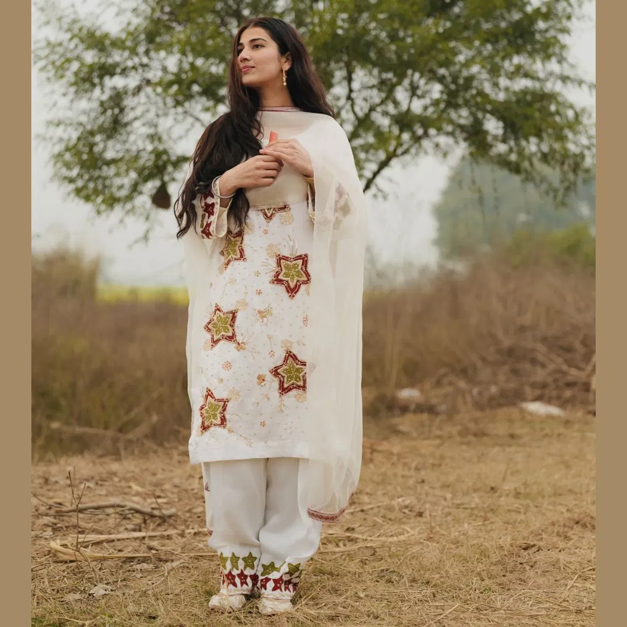 ਤੁਸੀਂ ਤਿਉਹਾਰਾਂ ਦੇ ਸੀਜ਼ਨ ਦੌਰਾਨ ਪਰੀ ਪੰਧੇਰ ਦੇ ਇਸ ਲੁੱਕ ਨੂੰ ਵੀ ਰਿਕ੍ਰਿਏਟ ਕਰ ਸਕਦੇ ਹੋ। ਉਨ੍ਹਾਂ ਨੇ ਇੱਕ ਵਾਈਟ ਕਲਰ ਦਾ ਸਲਵਾਰ-ਸੂਟ ਕੈਰੀ ਕੀਤਾ ਹੈ, ਜਿਸ ਵਿੱਚ ਕੁੜਤੀ 'ਤੇ ਸਟਾਰ ਪੈਟਰਨ ਦੀ ਕਢਾਈ ਕੀਤੀ ਗਈ ਹੈ। ਫਲੋਈ ਫੈਬਰਿਕ ਦਾ ਬਣਿਆ ਸਿੰਪਲ ਦੁਪੱਟਾ ਉਨ੍ਹਾਂਦੇ ਲੁੱਕ ਵਿੱਚ ਐਲੀਗੈਂਸ ਐਡ ਕਰ ਰਿਹਾ ਹੈ। ਮਿਨੀਮਲਿਸਟਿਕ ਜੂਲਰੀ ਅਤੇ ਨੇਚੁਰਲ ਮੇਕਅਪ ਲੁੱਕ ਦੇ ਨਾਲ ਉਨ੍ਹਾਂ ਦੀ ਬਿਊਟੀ ਹੋਰ ਵੀ ਐਨਹੈਂਸ ਹੋ ਰਹੀ ਹੈ।