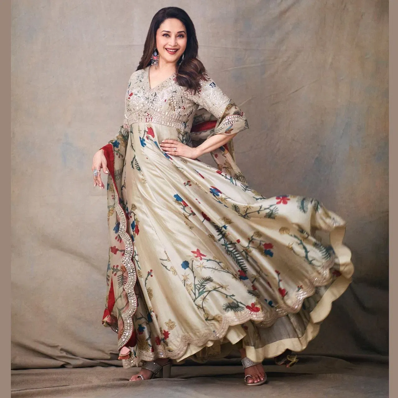 ਮਾਧੁਰੀ ਦੀਕਸ਼ਿਤ ਅੱਜ ਵੀ ਲੋਕਾਂ ਦੇ ਦਿਲਾਂ 'ਤੇ ਰਾਜ ਕਰਦੀ ਹੈ, ਅਤੇ ਉਨ੍ਹਾਂ ਦਾ ਫੈਸ਼ਨ ਯੰਗ ਗਰਲਸ ਲਈ ਇੰਸੀਪਰੇਸ਼ਨ ਹੈ। ਉਨ੍ਹਾਂ ਨੇ ਫਲੋਰਲ ਅਨਾਰਕਲੀ ਸੂਟ ਕੈਰੀ ਕੀਤਾ ਹੋਇਆ ਹੈ, ਜੋ ਬਹੁਤ ਹੀ ਸੁੰਦਰ ਅਤੇ ਸ਼ਾਨਦਾਰ ਦਿਖਾਈ ਦੇ ਰਿਹਾ ਹੈ। ਬਾਟਮ ਵਿੱਚ ਫਲੋਰਲ ਪ੍ਰਿੰਟ ਹੈ, ਜਦੋਂ ਕਿ ਟਾਪ ਵਿੱਚ ਬਾਰੀਕ ਕਢਾਈ ਕੀਤੀ ਗਈ ਹੈ। ਫਲੇਅਰਡ ਏ-ਲਾਈਨ ਕਲੀਆਂ ਦੀ ਡਿਟੇਲਿੰਗ ਨਾਲ ਤਿਆਰ ਕੀਤੀ ਗਈ ਹੈ, ਅਤੇ ਹੇਮਲਾਈਨ ਵਿੱਚ  ਕਰਲ ਡਿਜ਼ਾਈਨ ਅਤੇ ਮਿਰਰ ਵਰਕ ਹੈ। ਦੁਪੱਟੇ ਵਿੱਚ ਕਿਨਾਰਿਆਂ 'ਤੇ ਮਿਰਰ ਵਰਕ ਕੀਤਾ ਗਿਆ ਹੈ।