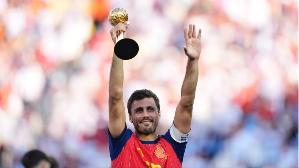 ਫੀਫਾ ਵਰਲਡ ਕੱਪ 2026 ਵਿੱਚ ਗੋਲਡਨ ਬਾਲ (Golden Ball) ਦਾ ਐਵਾਰਡ ਸਪੇਨ ਦੇ ਕਪਤਾਨ ਰੋਡਰੀ ਨੂੰ ਮਿਲਿਆ। ਇਹ ਐਵਾਰਡ ਟੂਰਨਾਮੈਂਟ ਦੇ ਸਭ ਤੋਂ ਸ਼ਾਨਦਾਰ ਪ੍ਰਦਰਸ਼ਨ ਕਰਨ ਵਾਲੇ ਖਿਡਾਰੀ ਨੂੰ ਦਿੱਤਾ ਜਾਂਦਾ ਹੈ ਅਤੇ ਰੋਡਰੀ ਨੇ ਆਪਣੀ ਟੀਮ ਲਈ ਪੂਰੇ ਟੂਰਨਾਮੈਂਟ ਦੌਰਾਨ ਬੇਹੱਦ ਪ੍ਰਭਾਵਸ਼ਾਲੀ ਖੇਡ ਦਿਖਾਈ। ਉਨ੍ਹਾਂ ਦੀ ਸ਼ਾਨਦਾਰ ਕਪਤਾਨੀ ਅਤੇ ਮਿਡਫੀਲਡ ਵਿੱਚ ਲਾਜਵਾਬ ਪ੍ਰਦਰਸ਼ਨ ਨੇ ਸਪੇਨ ਨੂੰ ਚੈਂਪੀਅਨ ਬਣਾਉਣ ਵਿੱਚ ਅਹਿਮ ਭੂਮਿਕਾ ਨਿਭਾਈ। (ਫੋਟੋ: PTI)