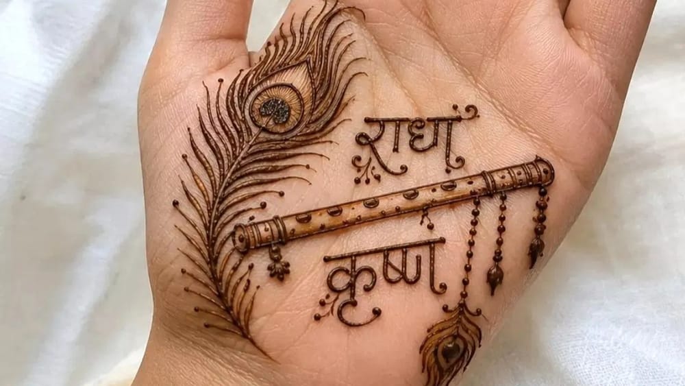 ਇਹ ਮਾਡਰਨ ਮਿਨੀਮਲ ਸਟਾਈਲ ਦਾ ਡਿਜ਼ਾਈਨ ਹੈ, ਜਿਸ ਵਿੱਚ ਇੱਕ ਵੱਡਾ ਮੋਰ ਪੰਖ, ਬੰਸਰੀ, ਉੱਪਰ “ਰਾਧਾ” ਅਤੇ ਹੇਠਾਂ “ਕ੍ਰਿਸ਼ਨ” ਲਿਖਿਆ ਹੋਇਆ ਹੈ। ਕਲਾਈ 'ਤੇ ਐਲੀਗੈਂਟ ਬੀਡਡ ਬ੍ਰੇਸਲੇਟ ਡਿਜ਼ਾਈਨ ਦਿੱਤਾ ਗਿਆ ਹੈ। ਇਹ ਕਲੀਨ ਸਪੇਸਿੰਗ ਅਤੇ ਲਾਈਟ-ਮੀਡੀਅਮ ਡੈਂਸਿਟੀ ਵਾਲਾ ਟ੍ਰੈਂਡੀ ਥੀਮ-ਬੇਸਡ ਮਹਿੰਦੀ ਡਿਜ਼ਾਈਨ ਹੈ।