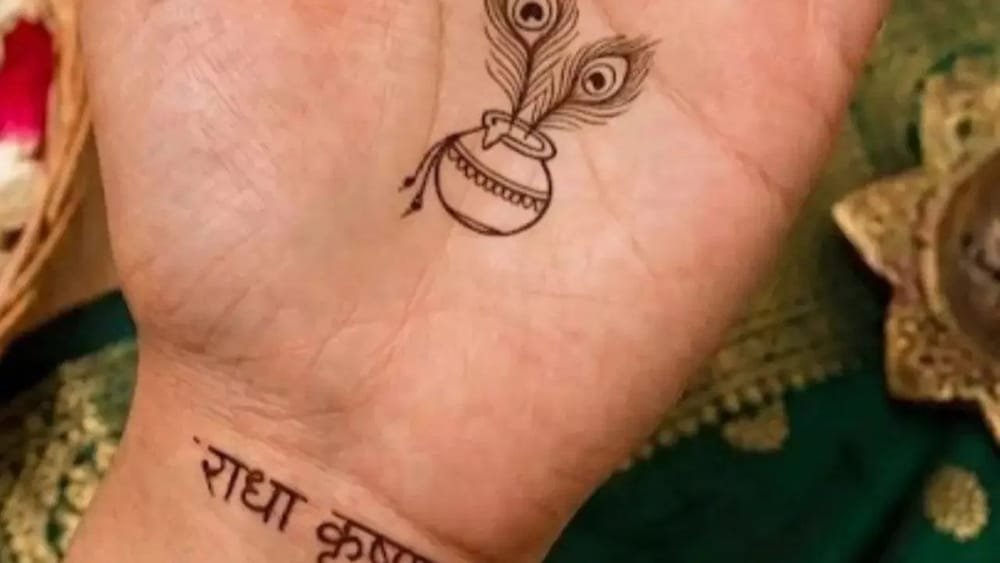 ਜਨਮਾਸ਼ਟਮੀ 'ਤੇ ਤੁਸੀਂ ਇਸ ਤਰ੍ਹਾਂ ਦੇ ਮਹਿੰਦੀ ਡਿਜ਼ਾਈਨ ਨਾਲ ਹੱਥਾਂ ਦੀ ਖੂਬਸੂਰਤੀ ਵਧਾ ਸਕਦੇ ਹੋ। ਇਸ ਵਿੱਚ ਸਿਰਫ਼ ਇੱਕ ਛੋਟਾ ਮਟਕਾ, ਹਥੇਲੀ ਦੇ ਵਿਚਕਾਰ ਦੋ ਮੋਰ ਪੰਖ ਅਤੇ ਕਲਾਈ 'ਤੇ ਸਿੰਪਲ “ਰਾਧਾ ਕ੍ਰਿਸ਼ਨ” ਟੈਕਸਟ ਲਿਖਿਆ ਗਿਆ ਹੈ। ਬਹੁਤ ਘੱਟ ਐਲੀਮੈਂਟਸ ਅਤੇ ਫਾਈਨ ਲਾਈਨ ਵਰਕ ਸ਼ਾਨਦਾਰ ਲੱਗ ਰਿਹਾ ਹੈ। ਇਹ ਕੰਟੈਂਪਰੇਰੀ ਮਿਨੀਮਲ ਮਹਿੰਦੀ ਡਿਜ਼ਾਈਨ ਹੈ, ਜੋ ਬਹੁਤ ਸਬਟਲ ਅਤੇ ਕਲਾਸੀ ਲੱਗ ਰਿਹਾ ਹੈ।